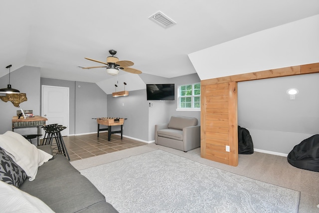 living room featuring ceiling fan, carpet floors, and vaulted ceiling