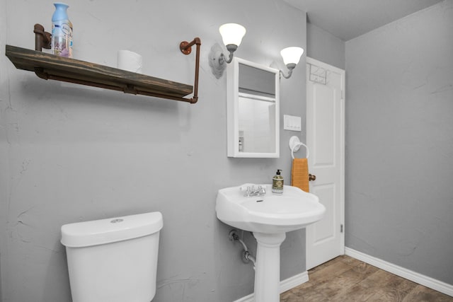 bathroom with hardwood / wood-style floors and toilet