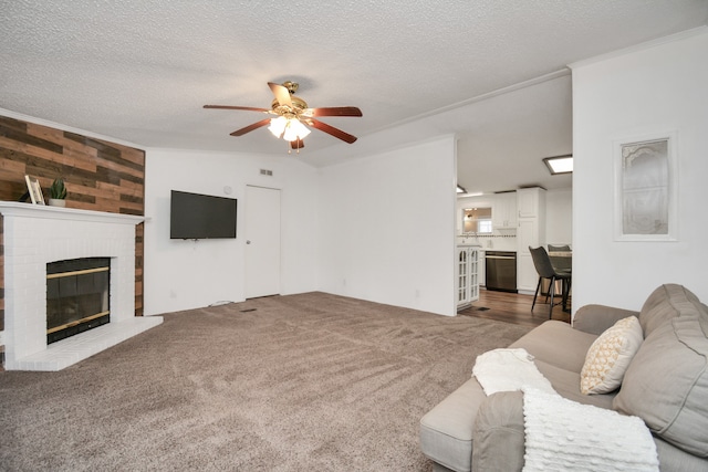 carpeted living room featuring a textured ceiling, a brick fireplace, ceiling fan, and wooden walls