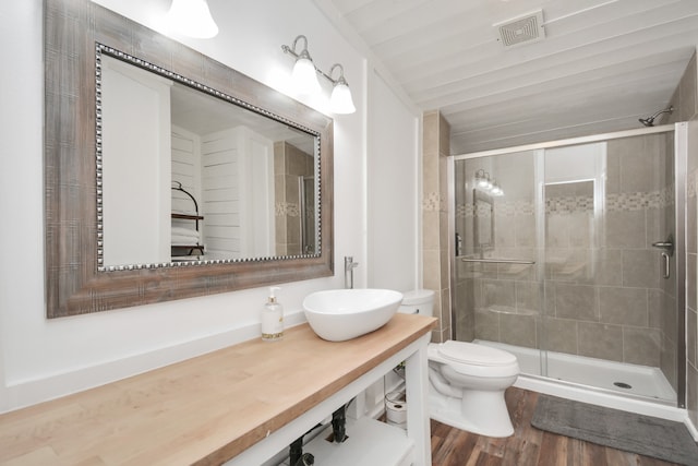 bathroom with hardwood / wood-style flooring, vanity, toilet, and walk in shower