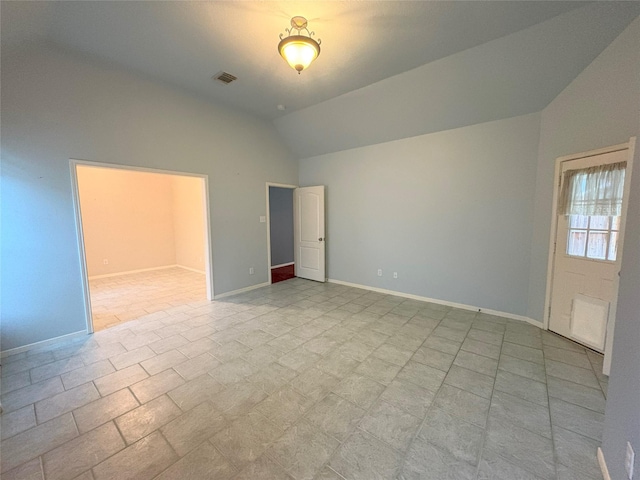 tiled empty room with lofted ceiling