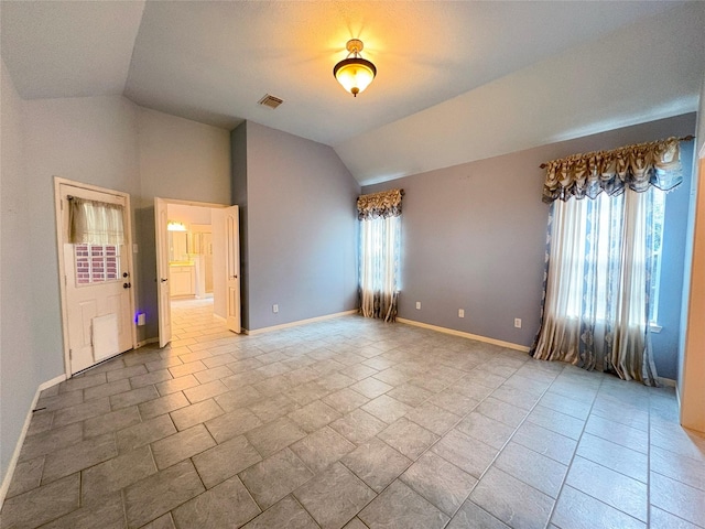 spare room featuring vaulted ceiling