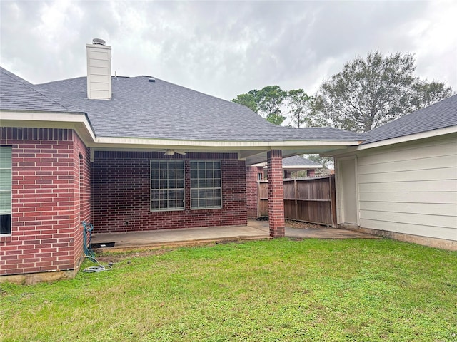 rear view of house with a yard and a patio