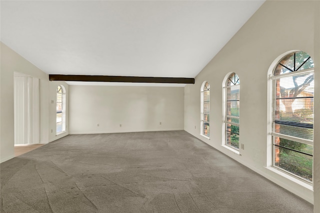 carpeted empty room featuring lofted ceiling with beams