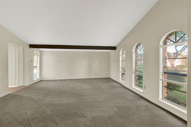 carpeted spare room featuring vaulted ceiling with beams