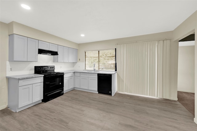 kitchen with light wood-type flooring, sink, and black appliances