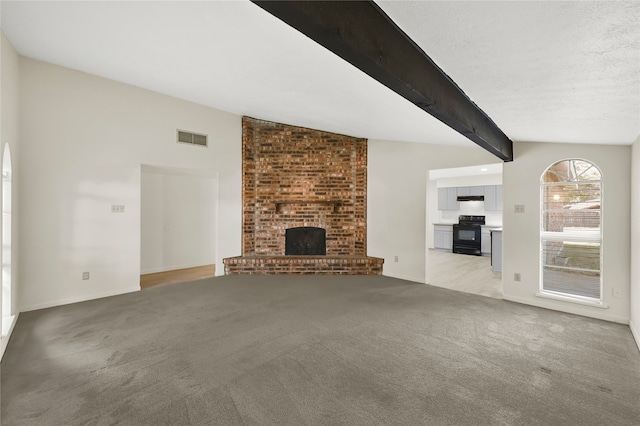 unfurnished living room with lofted ceiling with beams, light colored carpet, and a brick fireplace