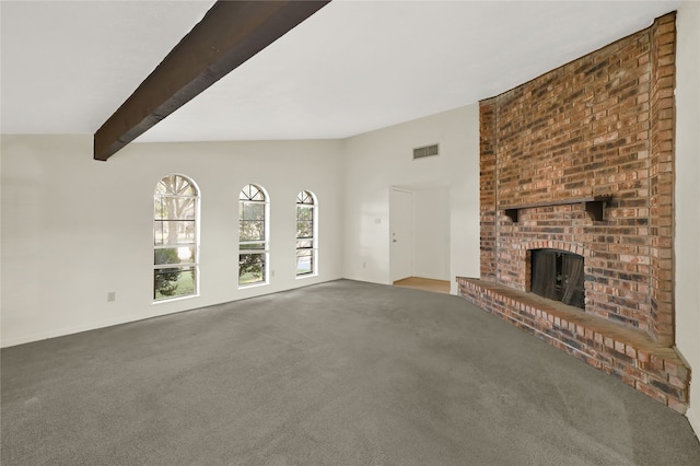 unfurnished living room with lofted ceiling with beams, carpet floors, and a brick fireplace