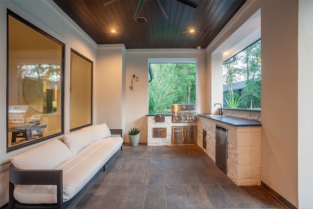 view of patio / terrace with an outdoor living space, ceiling fan, area for grilling, and exterior kitchen