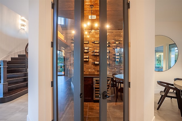 wine room featuring tile patterned flooring and brick wall