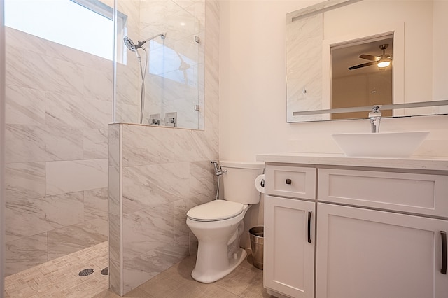 bathroom featuring vanity, tile patterned floors, ceiling fan, toilet, and tiled shower