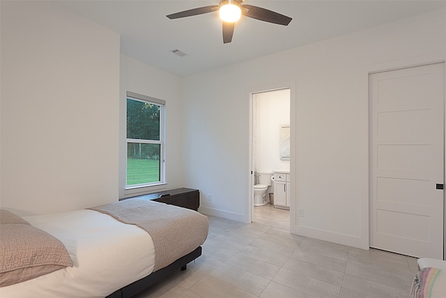 bedroom featuring ceiling fan, light tile patterned floors, and ensuite bath