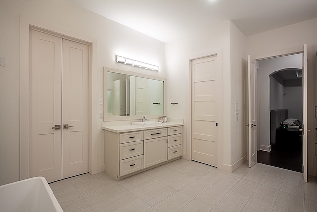 bathroom featuring a bathtub, vanity, and tile patterned flooring