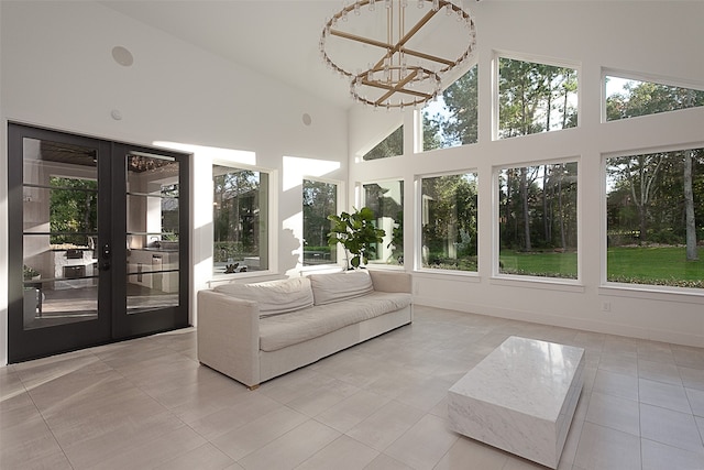 unfurnished sunroom featuring a chandelier, lofted ceiling, and french doors