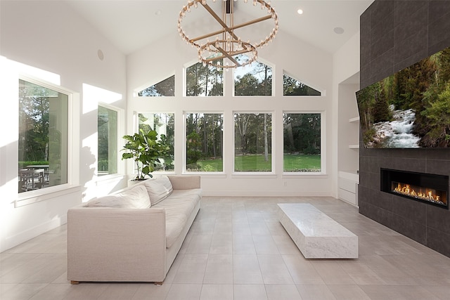 unfurnished sunroom featuring a tile fireplace, a chandelier, and lofted ceiling