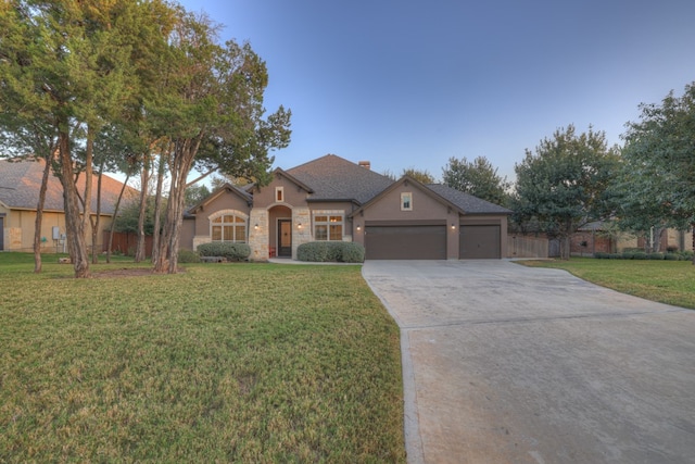 single story home with a garage and a front lawn