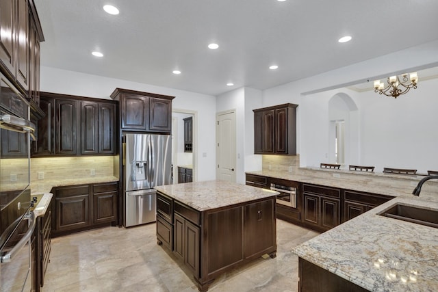 kitchen featuring backsplash, a center island, sink, and appliances with stainless steel finishes