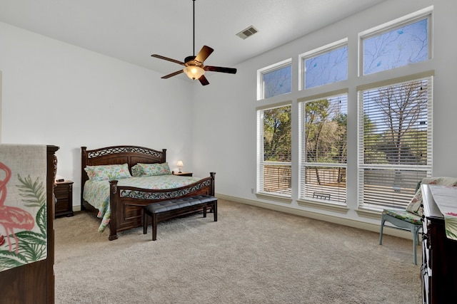 carpeted bedroom with ceiling fan and a towering ceiling