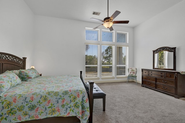 carpeted bedroom with ceiling fan, a towering ceiling, and multiple windows