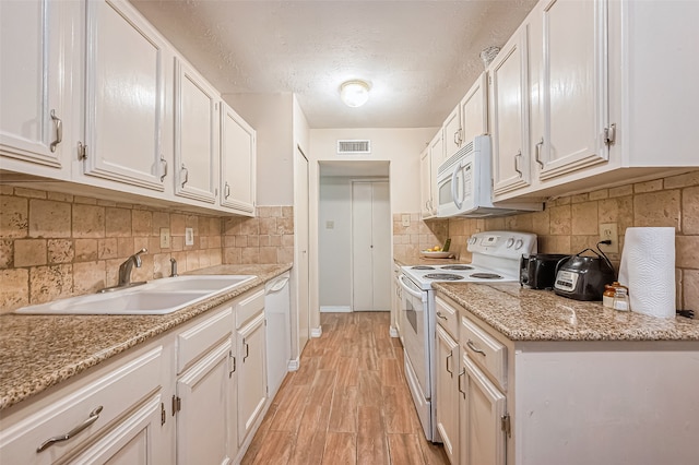 kitchen featuring a textured ceiling, sink, white cabinets, and white appliances