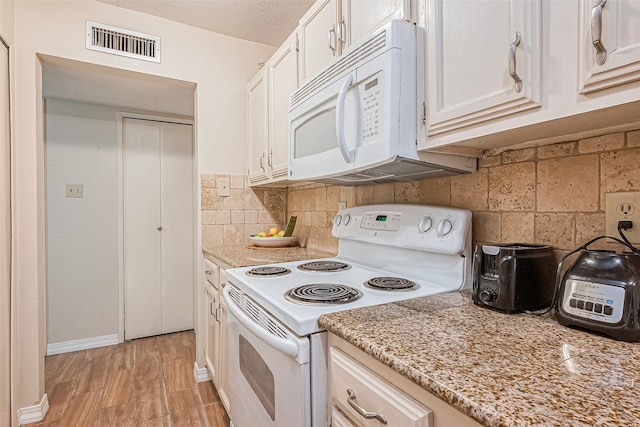 kitchen with light wood-type flooring, backsplash, white appliances, a textured ceiling, and white cabinets