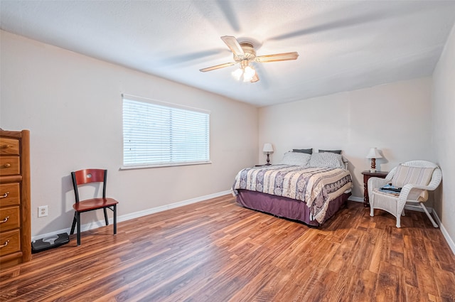 bedroom with dark hardwood / wood-style flooring and ceiling fan