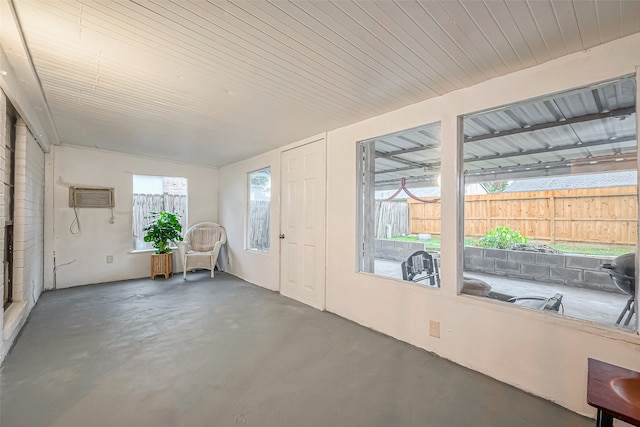 unfurnished sunroom with a wall mounted AC