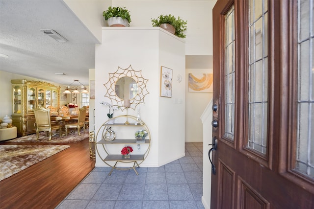 entryway featuring a textured ceiling and light hardwood / wood-style floors