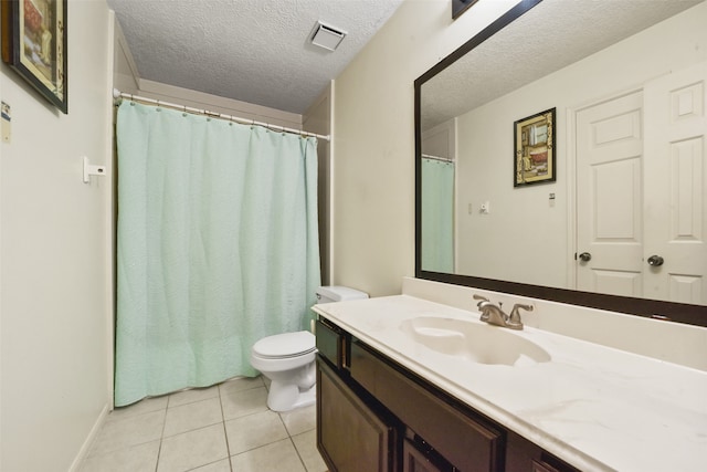 bathroom featuring tile patterned flooring, vanity, toilet, and a textured ceiling