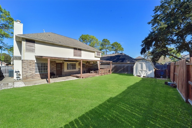 rear view of property with central AC unit, a storage unit, a yard, and a patio