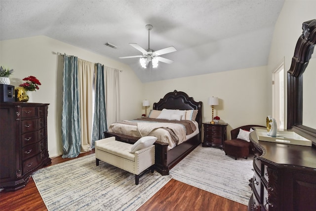 bedroom featuring wood-type flooring, a textured ceiling, vaulted ceiling, and ceiling fan