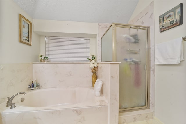 bathroom featuring separate shower and tub and a textured ceiling