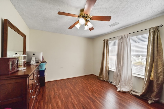 interior space featuring ceiling fan, dark wood-type flooring, and a textured ceiling