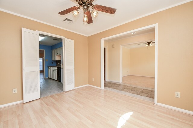 unfurnished room with ceiling fan, light hardwood / wood-style floors, and crown molding