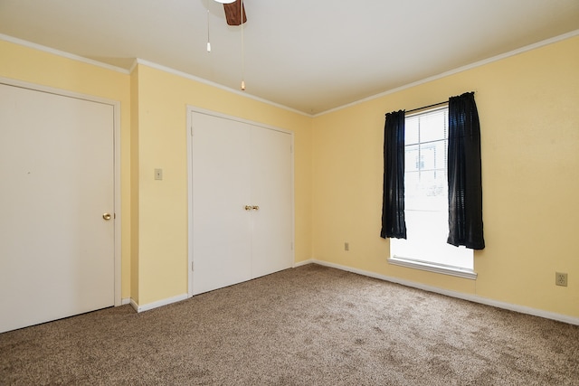 unfurnished bedroom featuring ceiling fan, carpet, and ornamental molding