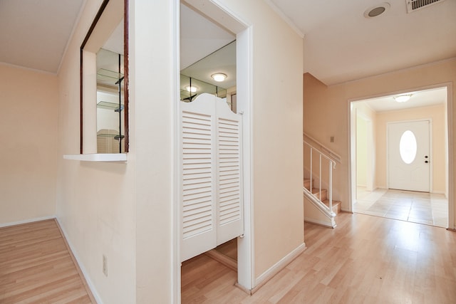 foyer with light hardwood / wood-style floors and crown molding