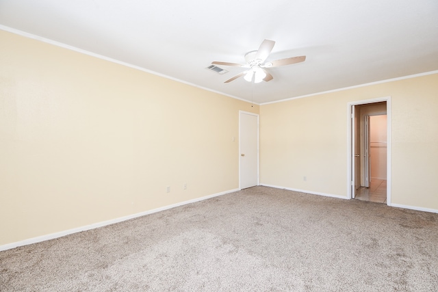 carpeted spare room with ceiling fan and crown molding