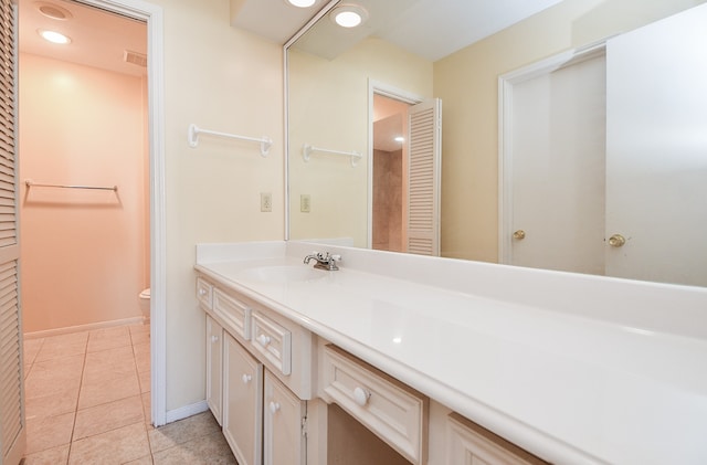 bathroom with tile patterned flooring, vanity, and toilet