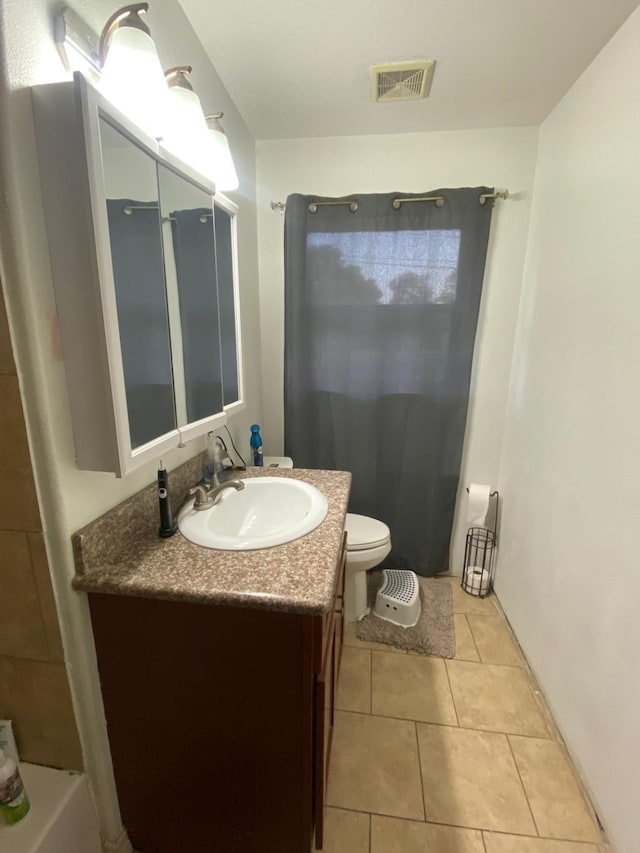 bathroom featuring tile patterned flooring, vanity, and toilet