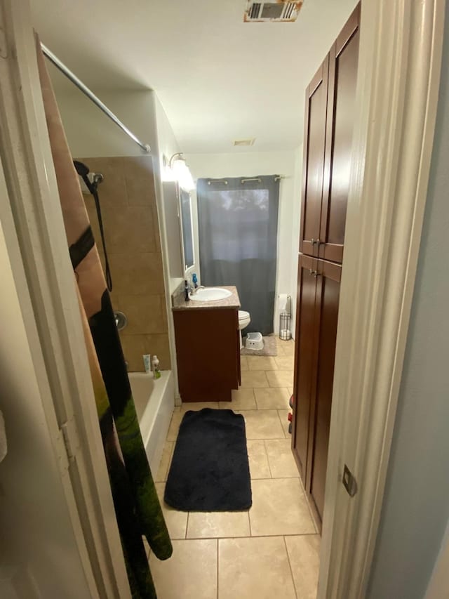 full bathroom featuring toilet, vanity, tile patterned floors, and shower / bath combo with shower curtain