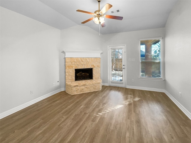 unfurnished living room with dark hardwood / wood-style flooring, a stone fireplace, ceiling fan, and lofted ceiling