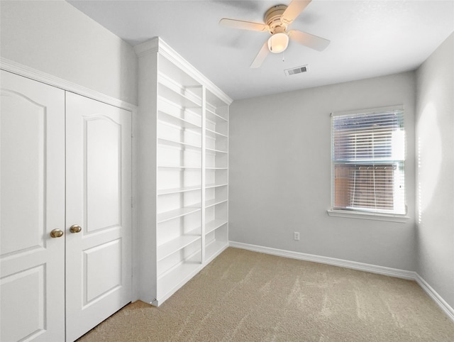 carpeted empty room featuring ceiling fan