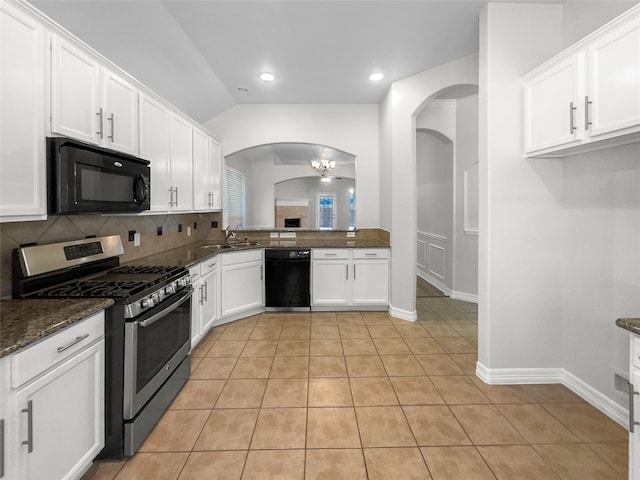 kitchen featuring vaulted ceiling, sink, black appliances, white cabinets, and light tile patterned flooring