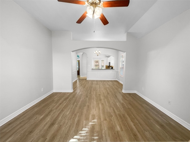 unfurnished living room with wood-type flooring and ceiling fan with notable chandelier