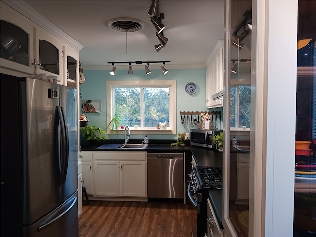 kitchen featuring white cabinetry, sink, dark wood-type flooring, appliances with stainless steel finishes, and ornamental molding