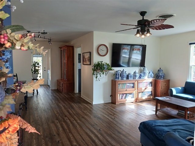 living room featuring ceiling fan and dark hardwood / wood-style flooring