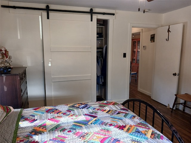 bedroom featuring hardwood / wood-style floors, a barn door, and a closet