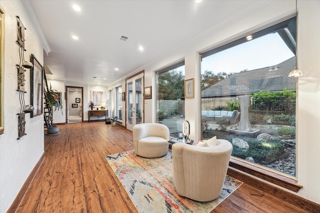 sitting room with ornamental molding and hardwood / wood-style flooring