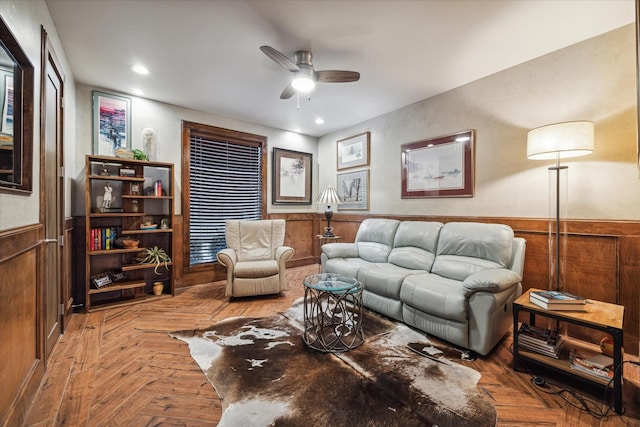 living room with wooden walls, light parquet flooring, and ceiling fan