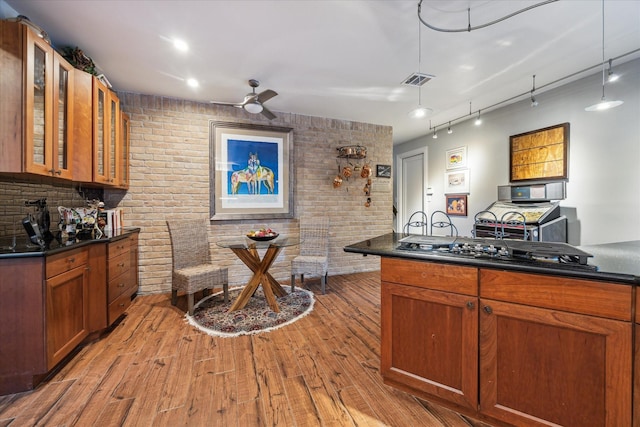 kitchen with decorative light fixtures, black gas cooktop, ceiling fan, light hardwood / wood-style flooring, and kitchen peninsula